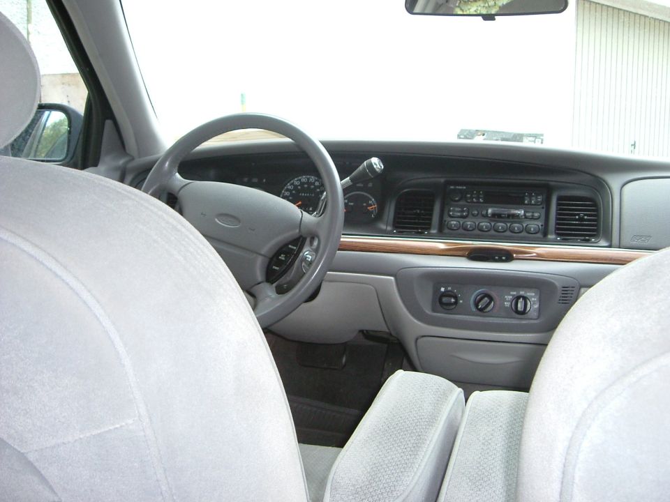 Interior view of a car's dashboard, steering wheel, and seats