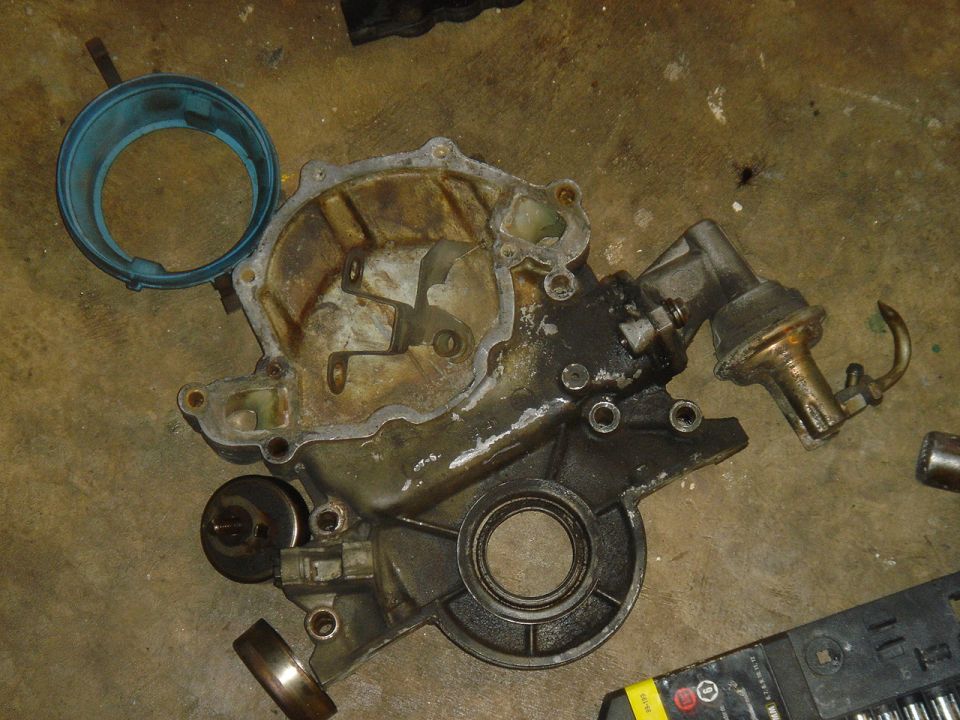 Engine timing cover assembly with attached fuel pump and a blue gasket ring nearby