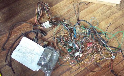 1985 Ford LTD Crown Victoria - A tangled wiring harness and a technical diagram are laid out on a wooden surface.