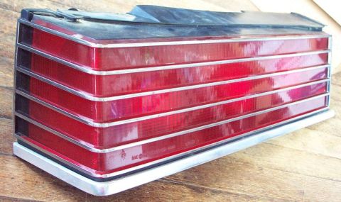 1985 Ford LTD Crown Victoria - A single car tail light assembly is shown, resting on a wooden surface.