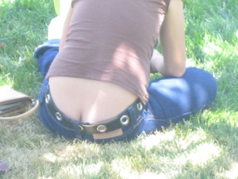 1990 Ford Bronco - close shot of a person in a brown top and blue jeans with a grommet-studded belt lying on green grass.