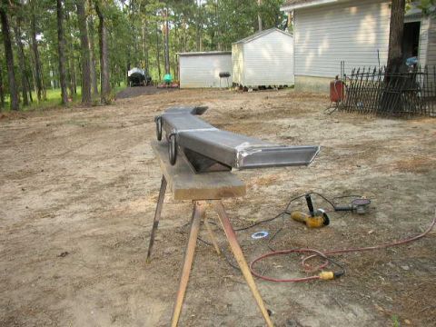 1995 Ford Bronco - A custom-fabricated metal bumper is shown on sawhorses, with tools for metalworking present.