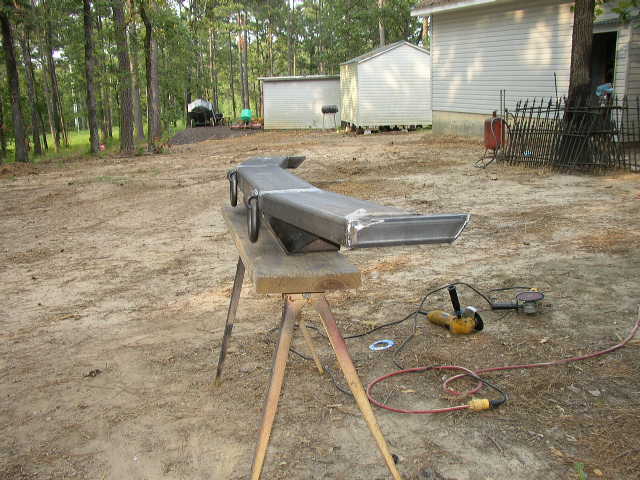 Metal bumper on sawhorses with grinder and sander nearby