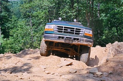1996 Ford Bronco - A 1996 Ford Bronco navigates a challenging off-road course with steep inclines and large rocks.