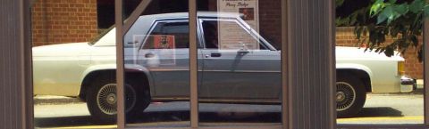 1985 Ford Crown Victoria LTD - A 1985 Ford Crown Victoria LTD is seen from the side, reflecting in a window.