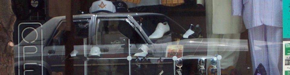 Store window display showing the interior of a car with shoes on the dashboard and seats