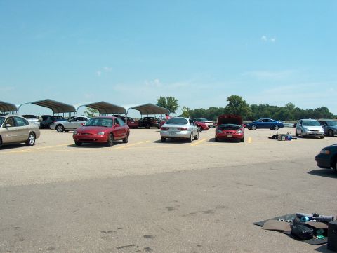 1998 Ford Taurus - A variety of vehicles are parked in an outdoor lot under a clear blue sky.