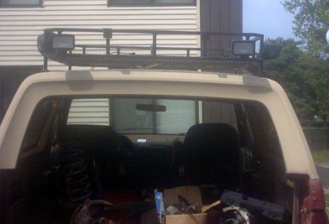 1989 Ford Bronco - The rear of a 1989 Ford Bronco is shown, equipped with a roof rack and auxiliary lights.