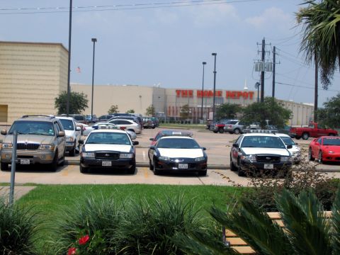2000 Ford Crown Victoria - Several police vehicles are parked in a lot outside a Home Depot store.