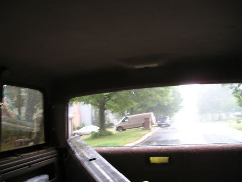 1996 Ford Bronco - View from inside a vehicle looking out at parked vehicles on a street.