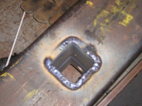 1996 Ford Bronco - Welded metal part with a square opening.