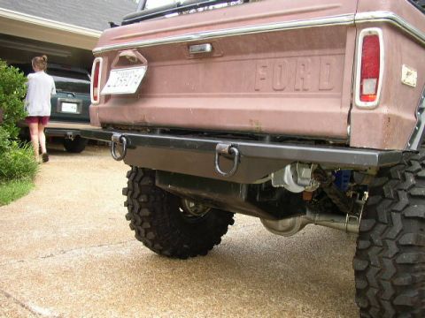 1995 Ford Bronco - Rear view of a brown Ford Bronco with a custom bumper and oversized tires, parked in a driveway.