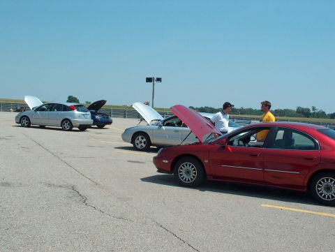 1998 Ford Taurus - Several cars are parked on a track with their hoods open, suggesting a car meet or event.