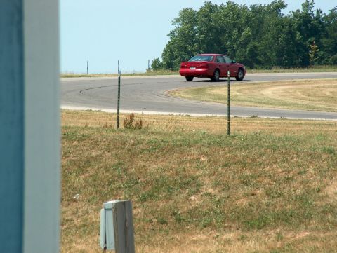 1998 Ford Taurus - A red 1998 Ford Taurus navigates a turn on a race track.
