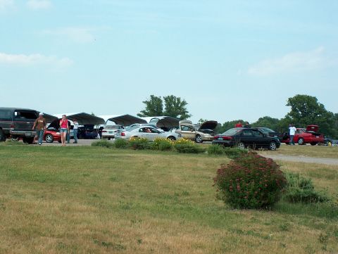 1998 Ford Taurus - Cars gathered outdoors, some with hoods open, under temporary shelters.