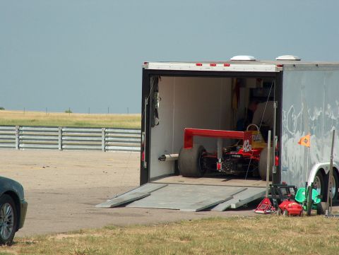 1998 Ford Taurus - Race car being loaded into a trailer at an outdoor event.