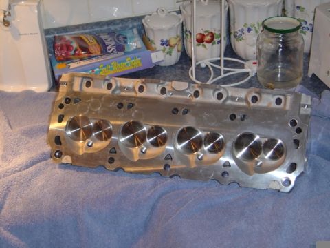 1986 Ford Bronco - A polished engine cylinder head rests on a blue towel, with kitchen counter items in the background.