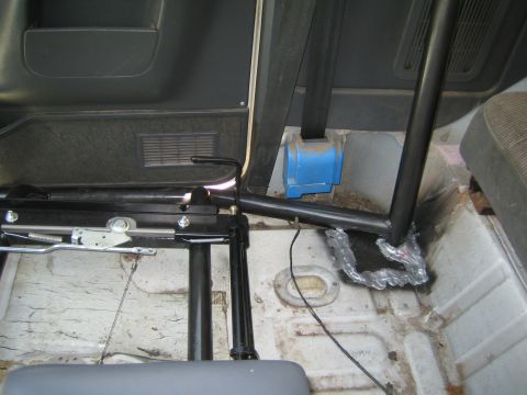 1990 Ford Bronco - interior floor of a vehicle under construction shows roll-bar tubing welded to the body near the seats and a blue duct.