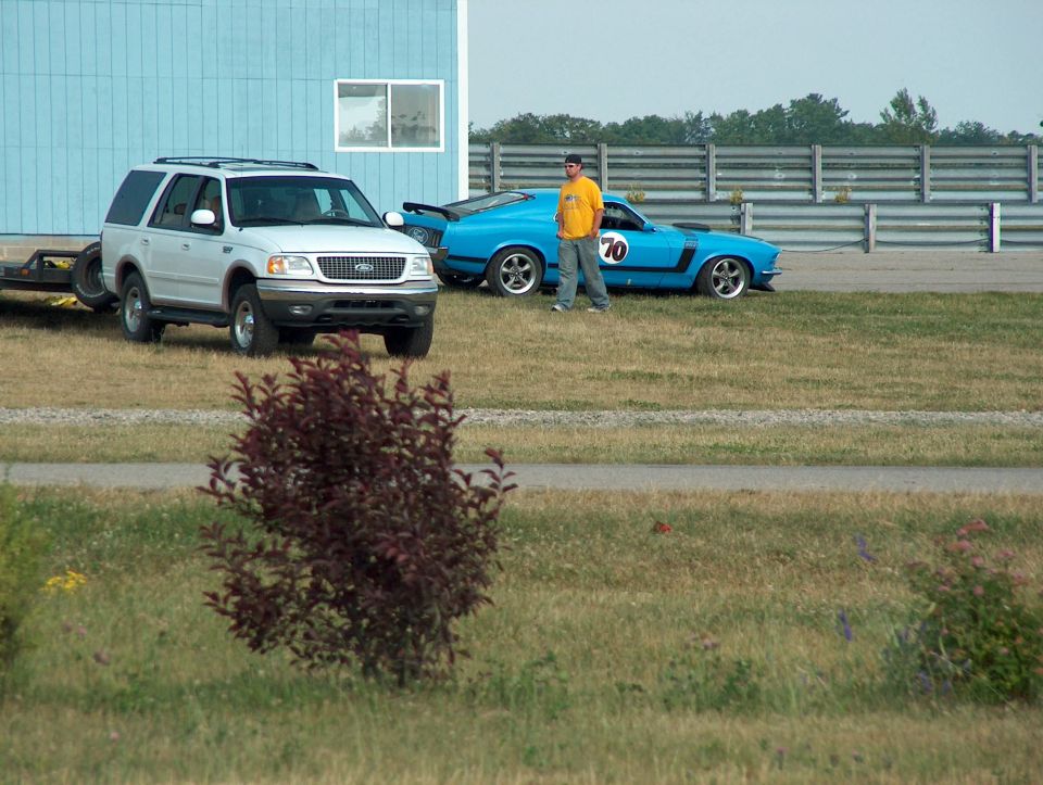White SUV parked next to a blue muscle car with number 70 on the door