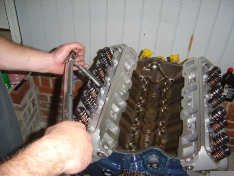 1986 Ford Bronco - Mechanic uses a torque wrench to install cylinder heads onto an engine block.