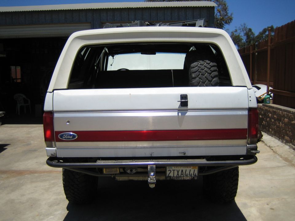 Rear of a lifted white Ford Bronco SUV with California plate 2TXA444 parked on a driveway