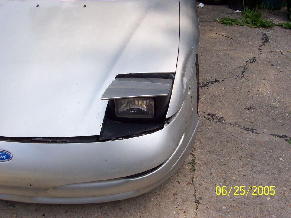Silver Ford Probe front end with pop-up headlight raised, parked on cracked concrete, dated 06/25/2005