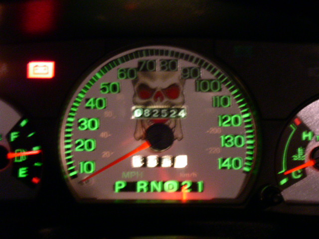 Dashboard gauges with a skull decal over the odometer reading 082524. Gear selector shows P R N D 2 1