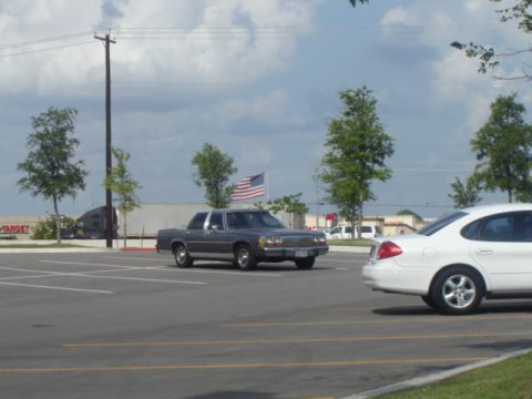 1988 Ford LTD Crown Victoria - Gray 1988 Ford Crown Victoria LTD parked in a lot with an American flag flying.