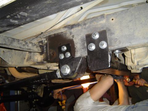 1989 Ford Bronco - Custom suspension brackets are being installed on the underbody of a vehicle.
