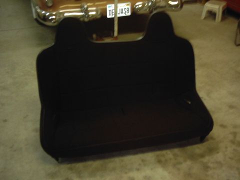 1978 Ford Bronco - A black rear seat is shown in front of a vehicle with a license plate.