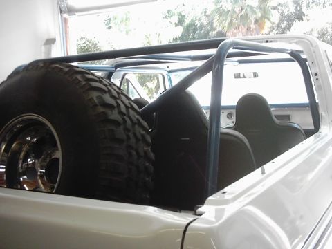 1978 Ford Bronco - Interior view of a 1978 Ford Bronco with a roll cage and spare tire mounted.