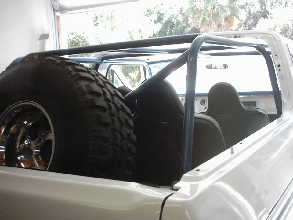 1978 Ford Bronco interior showing roll cage, spare tire, and rear seats