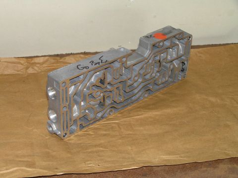 2000 Ford Excursion - A metal valve body with complex internal passages is shown, marked with handwritten text.