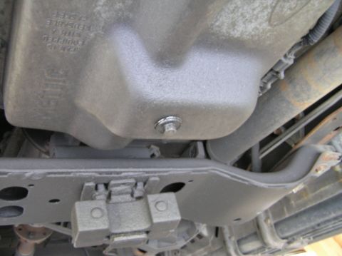 2000 Ford Excursion - Close-up of the oil pan and surrounding chassis parts from underneath a vehicle.