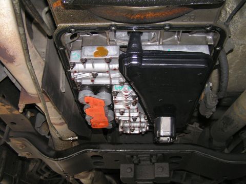 2000 Ford Excursion - Transmission pan and filter assembly, likely during a fluid change or repair.