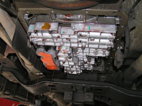 2000 Ford Excursion - Close-up of a vehicle's transmission valve body, showing internal components and some fluid leakage.