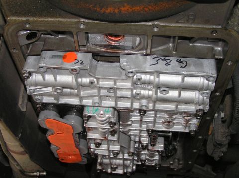 2000 Ford Excursion - Close-up view of a transmission valve body with visible markings and orange protective covers.