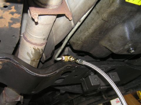 2000 Ford Excursion - Installation of a remote transmission filter line on a vehicle's underbody.