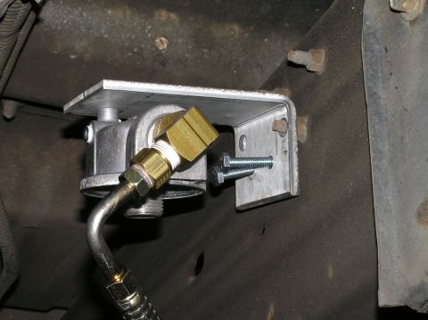2000 Ford Excursion - Close-up view of a remote transmission filter installation, showing the filter housing, brass fittings, and mounting bracket.