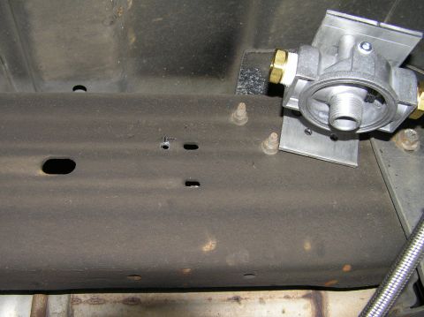 2000 Ford Excursion - A remote transmission filter assembly is attached to the vehicle's frame, showing the underside of the chassis.