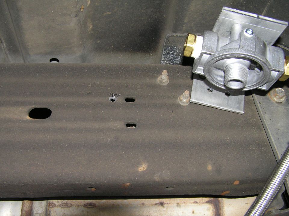 Underbody frame rail with drilled holes, studs, and an aluminum valve with brass fittings