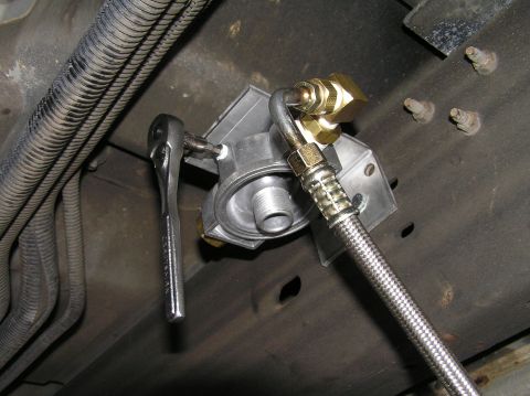 2000 Ford Excursion - A mechanic installs a remote transmission filter adapter onto a vehicle's frame.