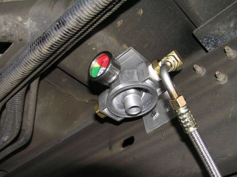2000 Ford Excursion - A remote transmission filter assembly with an integrated gauge is shown installed on a vehicle's undercarriage.