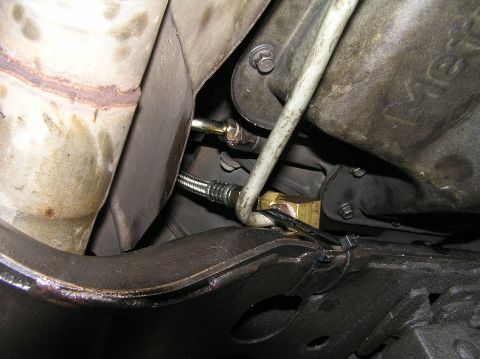 2000 Ford Excursion - Close-up view of transmission lines and exhaust system components from underneath a vehicle.