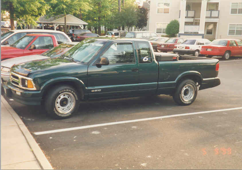 Dark green Chevrolet S-10 extended-cab pickup, side profile in parking lot
