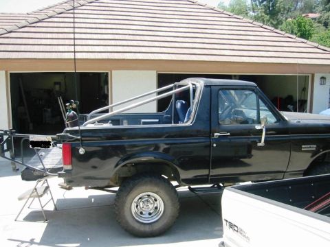 1985 Ford Bronco - This black Ford Bronco features a custom roll cage and appears to be a 1985 model.
