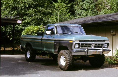 1976 Ford F-150 - This lifted Ford pickup truck features a two-tone paint scheme and prominent off-road tires.