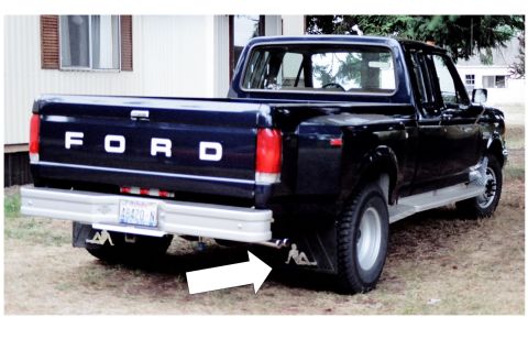 1976 Ford F-150 - Rear view of a dark blue Ford pickup truck with "FORD" on the tailgate and silhouette mud flaps.