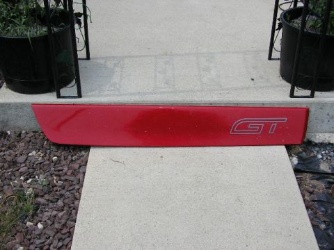 1994 Ford Probe - A red trim piece with a GT logo is shown resting on concrete steps.
