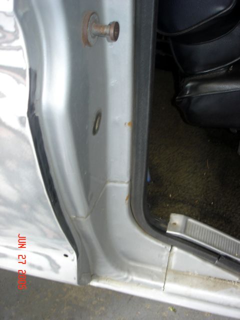 1979 Ford Bronco - Interior view of a vehicle's door jamb, showing the latch mechanism and part of the seat.